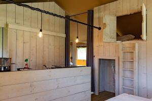 a kitchen with wooden walls and a counter in a room at Luxe Safaritent 6 persoons op Camping Rijsterbos in Rijs +10 photos