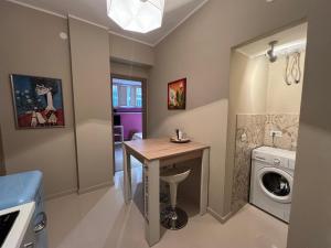 a laundry room with a table and a washing machine at Tavernetta Cortile Dalmazia in Catania