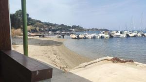een strand met boten in het water en een dok bij Maison de pêcheur à Giens les pieds dans l'eau ! in Hyères