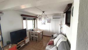 ein Wohnzimmer mit einem Sofa und einem Flachbild-TV in der Unterkunft Maison de pêcheur à Giens les pieds dans l'eau ! in Hyères