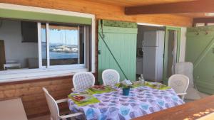 einen Tisch mit Essen drauf in einem Zimmer mit Fenster in der Unterkunft Maison de pêcheur à Giens les pieds dans l'eau ! in Hyères