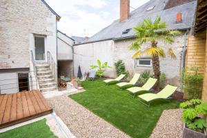 einen Garten mit Stühlen, einer Palme und einer Treppe in der Unterkunft Maison paradisiaque avec piscine in Mosnes
