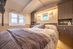 a bedroom with a large bed and two windows at Barleywood in South Creake
