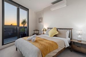 una camera da letto con un letto grande e una grande finestra di Zi apartments - with Balcony, Bayview, Sauna and Pool a Melbourne Altre 16 foto