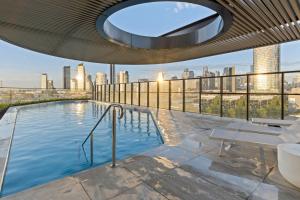 a swimming pool on top of a building with a city skyline at Zi apartments - with Balcony, Bayview, Sauna and Pool in Melbourne