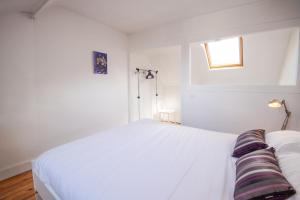 um quarto com uma cama branca e uma janela em "AU VINCI ROUGE" Downtown - Modern - Bright em Amboise