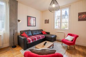uma sala de estar com um sofá de couro preto e cadeiras vermelhas em "AU VINCI ROUGE" Downtown - Modern - Bright em Amboise