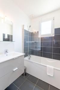 een witte badkamer met een bad en een wastafel bij Le Petit Choiseul - Superb bungalow sleeps 6 in Amboise