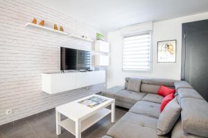 een woonkamer met een bank en een tv bij Le Petit Choiseul - Superb bungalow sleeps 6 in Amboise