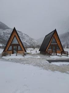 a group of three wooden huts in the snow at Wooden cottages "KONAK" in Šavnik