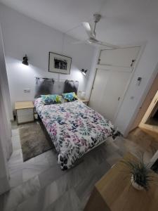 um quarto com uma cama com um edredão floral em Apt Erisa en Torremolinos dos min de la playa, Puerto Marina em Torremolinos