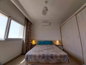 a bedroom with a bed and two windows at Amazing waterfront Apartment in Hurghada