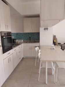 a kitchen with white cabinets and a table and chairs at Amazing waterfront Apartment in Hurghada
