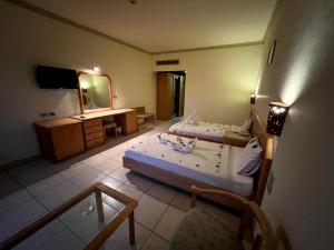 een slaapkamer met 2 bedden, een bureau en een spiegel bij Sharm Cliff Hotel in Sharm El Sheikh