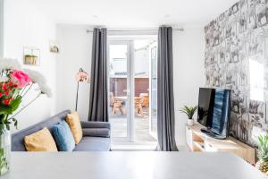 a living room with a blue couch and a tv at Modern 2 Bedroom Flat - Short Walk From The Station in Cambridge