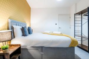 sypialnia z dużym białym łóżkiem z niebieskimi poduszkami w obiekcie Modern 2 Bedroom Flat - Short Walk From The Station w Cambridge