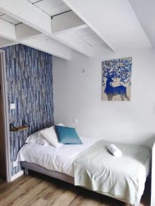 1 dormitorio con 1 cama y una pintura en la pared en Chez Soline - Le Duplex climatisé en Amboise