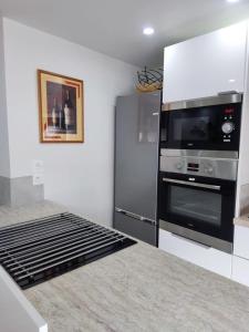 een keuken met een fornuis en een koelkast bij Chez Soline - Le Duplex climatisé in Amboise