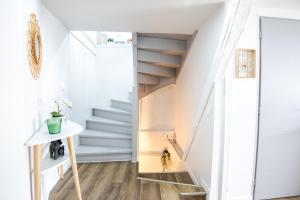 een trap in een kamer met witte muren en witte vloeren bij Chez Soline - Le Duplex climatisé in Amboise