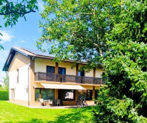 een huis met een balkon en een tuin bij Apartments AD Radenci in Radenci