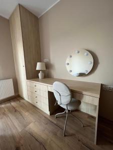 Habitación con escritorio con silla y espejo. en AgaApartments en Słupca