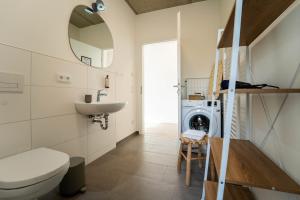 a bathroom with a sink and a washing machine at dreamcation Apartments Boardinghouse - Straubing Süd in Straubing