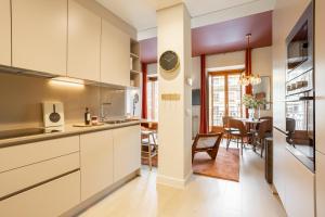a kitchen with white cabinets and a dining room at San Bernardo - Darya Living in Madrid