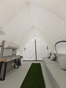 a living room with a couch and a desk in a tent at The Coco Journey - Eco Tent in Kelebang Besar