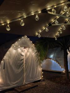 une grande tente blanche avec des lumières au-dessus dans l'établissement The Coco Journey - Eco Tent, à Kelebang Besar