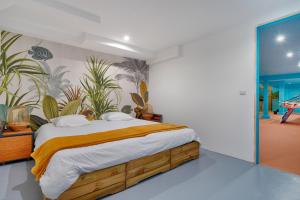Morsang-sur-SeineにあるVilla California Dream proche paris et disneyのベッドルーム1室(壁に植物が飾られたベッド1台付)