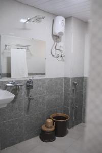 y baño con ducha, aseo y lavamanos. en Hotel Kalpesh, en Navi Mumbai