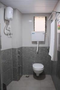 y baño con aseo y ducha. en Hotel Kalpesh, en Navi Mumbai