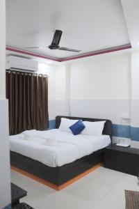 1 dormitorio con 1 cama y ventilador de techo en Hotel Kalpesh, en Navi Mumbai