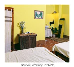 um quarto com paredes amarelas, uma cama e uma casa de banho em Lazánia homestay Đất Thánh-số 8a hẻm số 3 Phạm Văn Xuyên em Tây Ninh