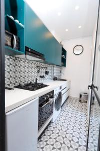 eine Küche mit blauen Schränken und einer Waschmaschine in der Unterkunft Élégance et Confort au Cœur d'Alger in El Madania