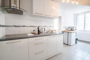 a white kitchen with white cabinets and a sink at Le Petit Marais in Amboise