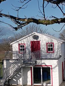 una casa bianca con finestre rosse e scala di Tiernan's luxury triple room Ensuite a Newtown-Dillon