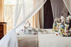 a bedroom with a white bed with a canopy at Umkumbe Bush Lodge - Luxury Tented Camp in Skukuza