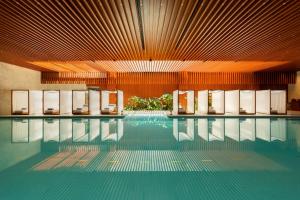 a swimming pool with chairs in a building at Bulgari Hotel Shanghai in Shanghai