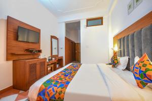 a bedroom with a large bed and a tv at FabHotel Prime Hemkunth in Kasauli