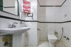 a white bathroom with a sink and a toilet at FabHotel Prime Hemkunth in Kasauli