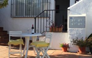 ネルハにあるUrb.Punta Lara, Plza. Sevilla 2, 1Dの白いテーブル(椅子2脚付)とワイン1本