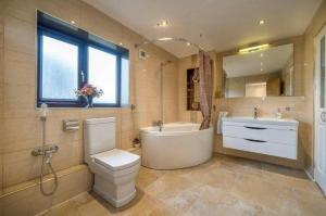 La salle de bains est pourvue d'une baignoire, de toilettes et d'un lavabo. dans l'établissement Executive Residence - Yorkshire Staycation Home, à Gomersal