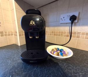 a coffee maker on a counter next to a bowl of balls at Orange Squirrel Lodge in Aviemore +23 photos