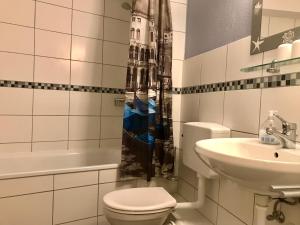 e bagno con servizi igienici, lavandino e doccia. di Ferienwohnung Strandkorb a Glücksburg