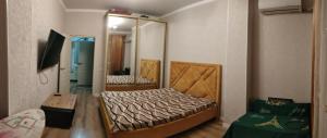 - une chambre avec un lit et un miroir dans l'établissement Сдаётся 2х комн кв в центре города ЖК Астана, à Aktau