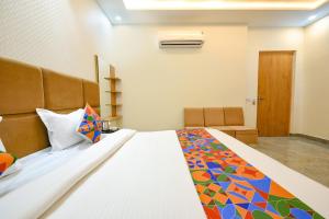 1 dormitorio con 1 cama grande con una manta colorida en FabHotel Flying Kiwi, en Mohali