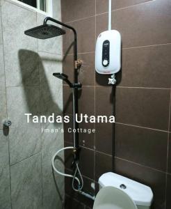 baño con aseo y teléfono en la pared en Iman’s Cottage Hospital Kulim Hitech, en Kulim