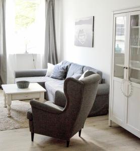 - un salon avec un canapé et une chaise dans l'établissement Ferienwohnung Charlotte, à Glücksburg