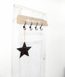 a wooden star hanging on a white door at Ferienwohnung Charlotte in Glücksburg